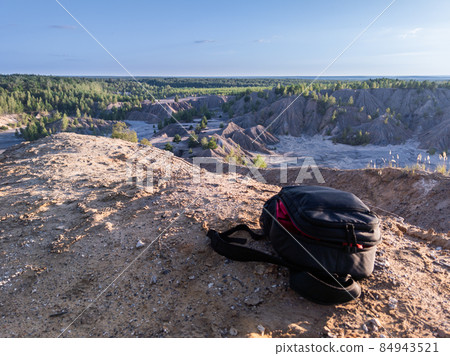 small black backpack on top of the hill at summer daytime small black backpack on top of the hill at summer daytime 84943521