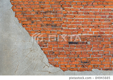 old bad brick wall with leftovers of gray peeled thick sandy plaster 84943885