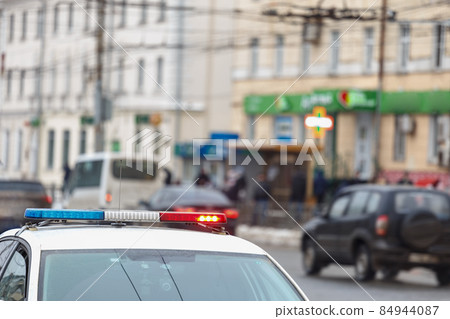 police car lights in city street with civilian cars traffic in blurry background in Tula, Russia 84944087