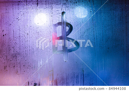 bitcoin symbol - handwritten on wet glass of night window 84944108