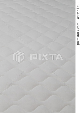 Soft white mattress close-up background with selective focus. 84944150