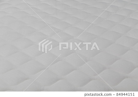 Soft white mattress close-up background with selective focus. 84944151