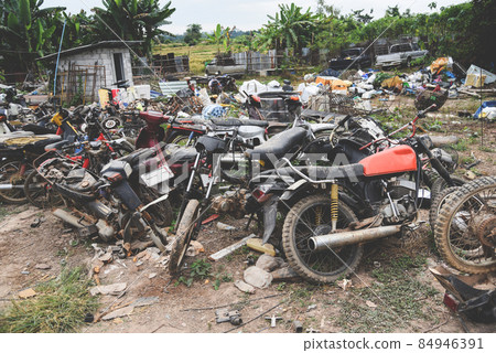waste scrap with engine motorcycle old rust ,heap of old rusty metal wheel rims in the vehicle waste waste scrap with engine motorcycle old rust ,heap of old rusty metal wheel rims in the vehicle waste 84946391
