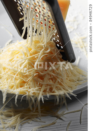 Grated cheese and grater. 84946729