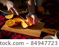 A woman is cutting an orange 84947723