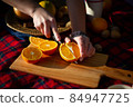 A woman is cutting an orange 84947725