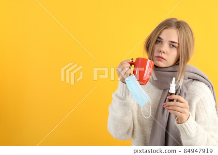 Ill young woman on yellow background, seasonal cold concept Ill young woman on yellow background, seasonal cold concept 84947919