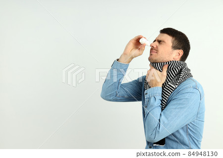 Young man with nasal spray on white background, runny nose concept 84948130