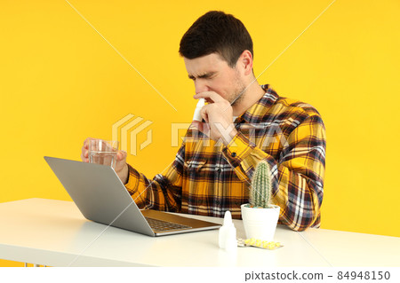 Ill young man sitting on workplace, seasonal cold concept 84948150