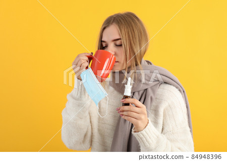 Ill young woman on yellow background, seasonal cold concept Ill young woman on yellow background, seasonal cold concept 84948396