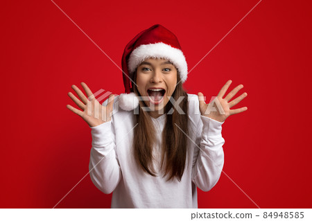 Amazing Offer. Portrait Of Surprised Woman In Santa Hats Exclaiming With Excitement Amazing Offer. Portrait Of Surprised Woman In Santa Hats Exclaiming With Excitement 84948585