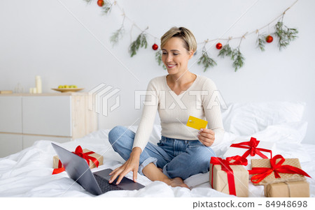 Xmas Shopping. Smiling woman using laptop and credit card 84948698