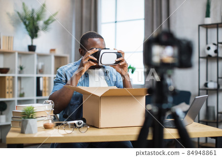 African american man opening parcel box and recording video African american man opening parcel box and recording video 84948861