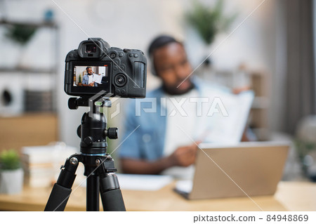 African man in headset having online conference from home African man in headset having online conference from home 84948869