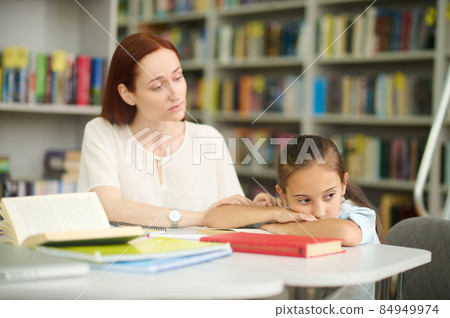 Caring woman touching hand of girl tired of studying 84949974