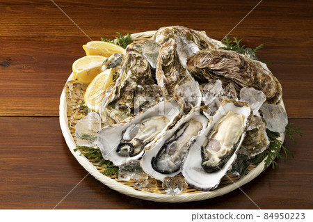 Oyster with shell on a colander_Background board Oyster with shell on a colander_Background board 84950223