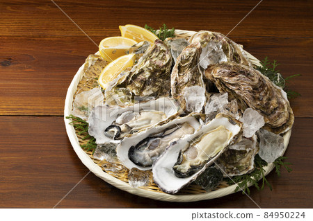 Oyster with shell on a colander_Background board Oyster with shell on a colander_Background board 84950224
