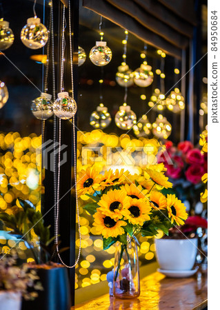 artificial sunflower in glass vase for decoration for Christmas decoration lights in the shape of on Bokeh background Decoration During Christmas and New Year. 84950684