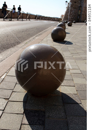 Brown painted stone spheres architectural design detail with shadow on tiled sidewalk background Brown painted stone spheres architectural design detail with shadow on tiled sidewalk background 84951184
