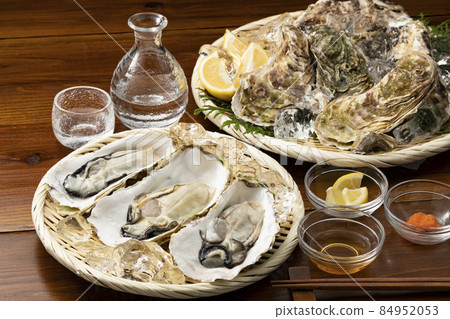 Raw oysters with shells and sake on a colander Raw oysters with shells and sake on a colander 84952053