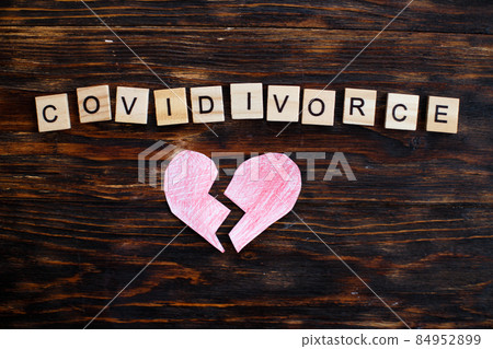 broken heart with inscription covidivorce made by wooden blocks on wooden background. broken heart with inscription covidivorce made by wooden blocks on wooden background. 84952899