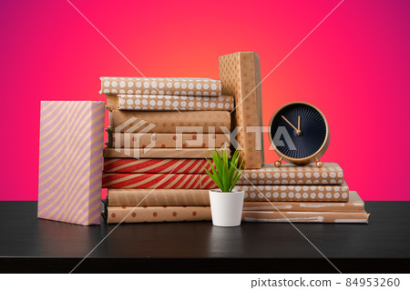 Education concept with stack of books on a table against colored background. 84953260