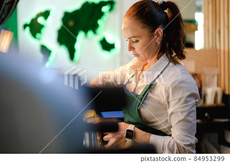 Caucasian female barista at work making coffee 84953299