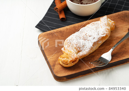 Traditional apple strudel on wooden board, close up Traditional apple strudel on wooden board, close up 84953340
