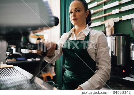 Caucasian female barista at work making coffee Caucasian female barista at work making coffee 84953342