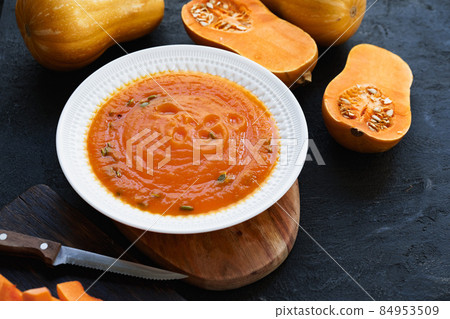 Homemade pumpkin soup on a black table Homemade pumpkin soup on a black table 84953509