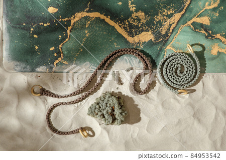 Unrolled moss green yoga mat, rope for stretching and dried moss on sandy beach. Relaxation and meditation wellbeing. Mindful living concept 84953542