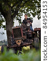 Young girl, old tractor and old oak 84954153