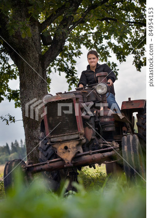 Young girl, old tractor and old oak Young girl, old tractor and old oak 84954153