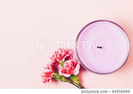 Scented candle next to fresh flowers bouquet Scented candle next to fresh flowers bouquet 84956899
