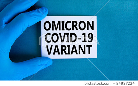 New covid-19 omicron variant strain symbol. Hand in blue glove with white card. Concept words Omicron covid-19 variant. Medical and COVID-19 omicron variant strain concept. Copy space. 84957224