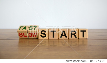 Time to fast start. Fliped wooden cubes and changes the words 'slow start' to 'fast start'. Beautiful wooden table, white background, copy space. Business and fast start concept. 84957338