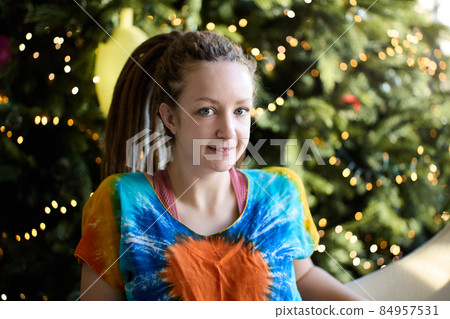 28 years old woman sits near Christmas tree on Christmas Eve. 28 years old woman sits near Christmas tree on Christmas Eve. 84957531