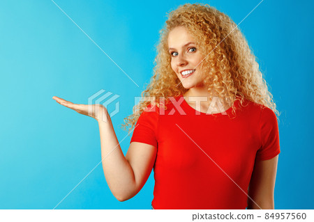 Young attractive blonde woman pointing her finger to copy space Young attractive blonde woman pointing her finger to copy space 84957560