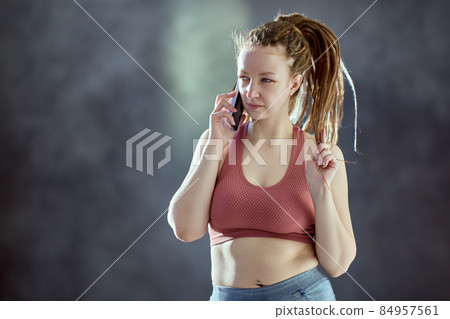 Caucasian woman with braided hair speaks on telephone. Caucasian woman with braided hair speaks on telephone. 84957561