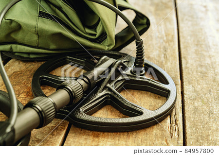 Metal detector tool on wooden board close up 84957800