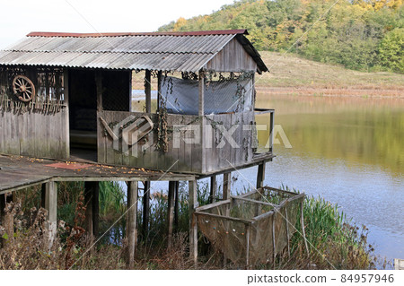 Small fisherman's house near the lake. The house is on stilts. Small fisherman's house near the lake. The house is on stilts. 84957946