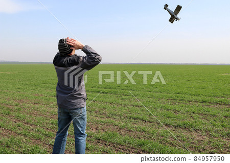 A farmer standing on his wheat field sees a small plane overhead about to crash. Digital composition. A farmer standing on his wheat field sees a small plane overhead about to crash. Digital composition. 84957950