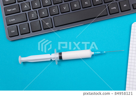 Vaccination or Revaccination Concept - A Medical Syringe on Blue Table 84958121