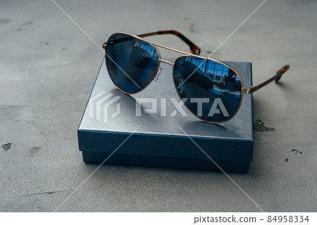 New dark aviator glasses on grey concrete background New dark aviator glasses on grey concrete background 84958334