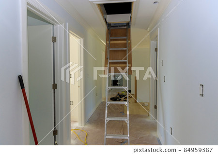 Pull down folding attic ladder stairs in small hallway 84959387