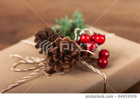 Gift box with winter decor on wooden table. 84959509