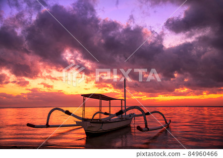 Beautiful sunrise scenery with Jukung is traditional balinese fishing boats at Karang Beach, Sanur, Bali, Indonesia. Beautiful sunrise scenery with Jukung is traditional balinese fishing boats at Karang Beach, Sanur, Bali, Indonesia. 84960466