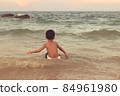 A boy playing in the sea having fun alone 84961980