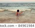 A boy playing in the sea having fun alone 84961984