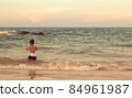 A boy playing in the sea having fun alone 84961987